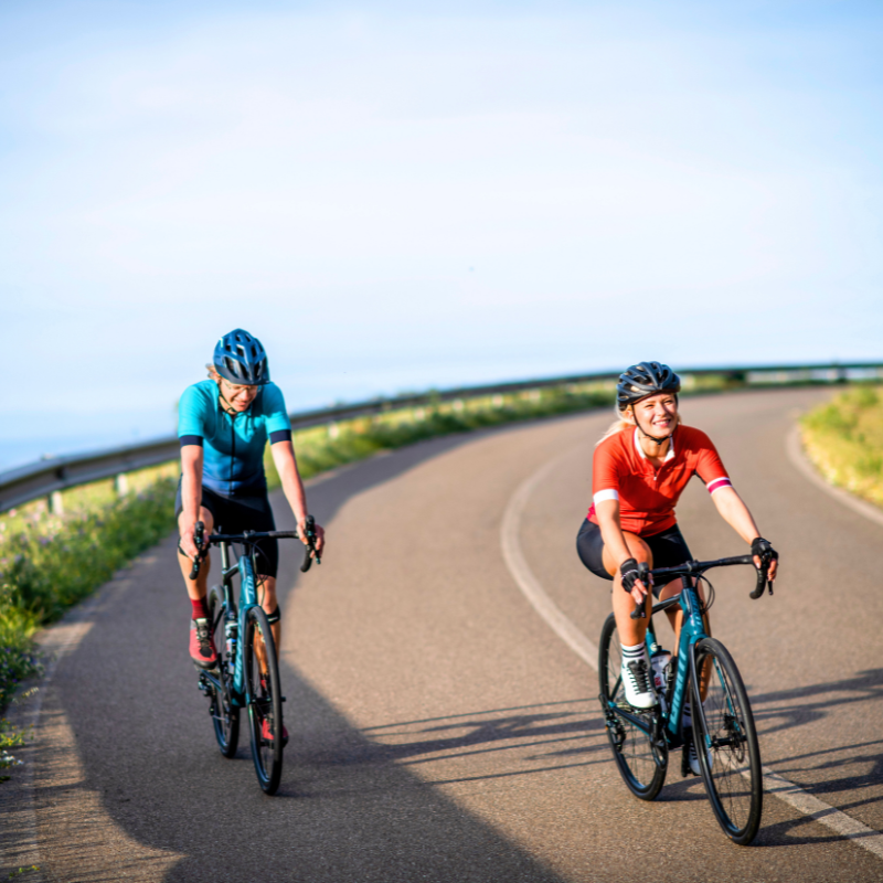 Two happy road cyclists riding in Italy on a cycling tour